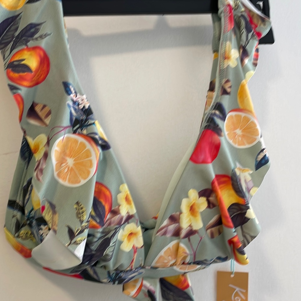 Bikini top with a tie in the back. Ruffles on the side size small new with tag